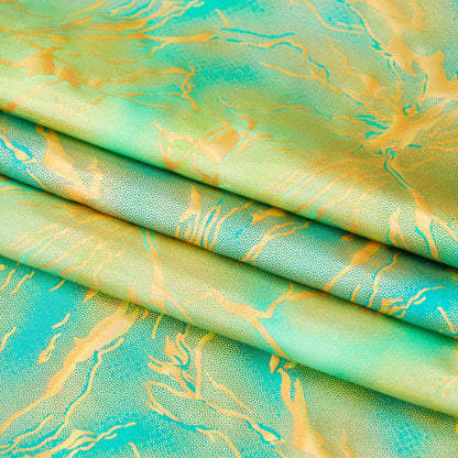 Folded fabric with a green and gold abstract pattern